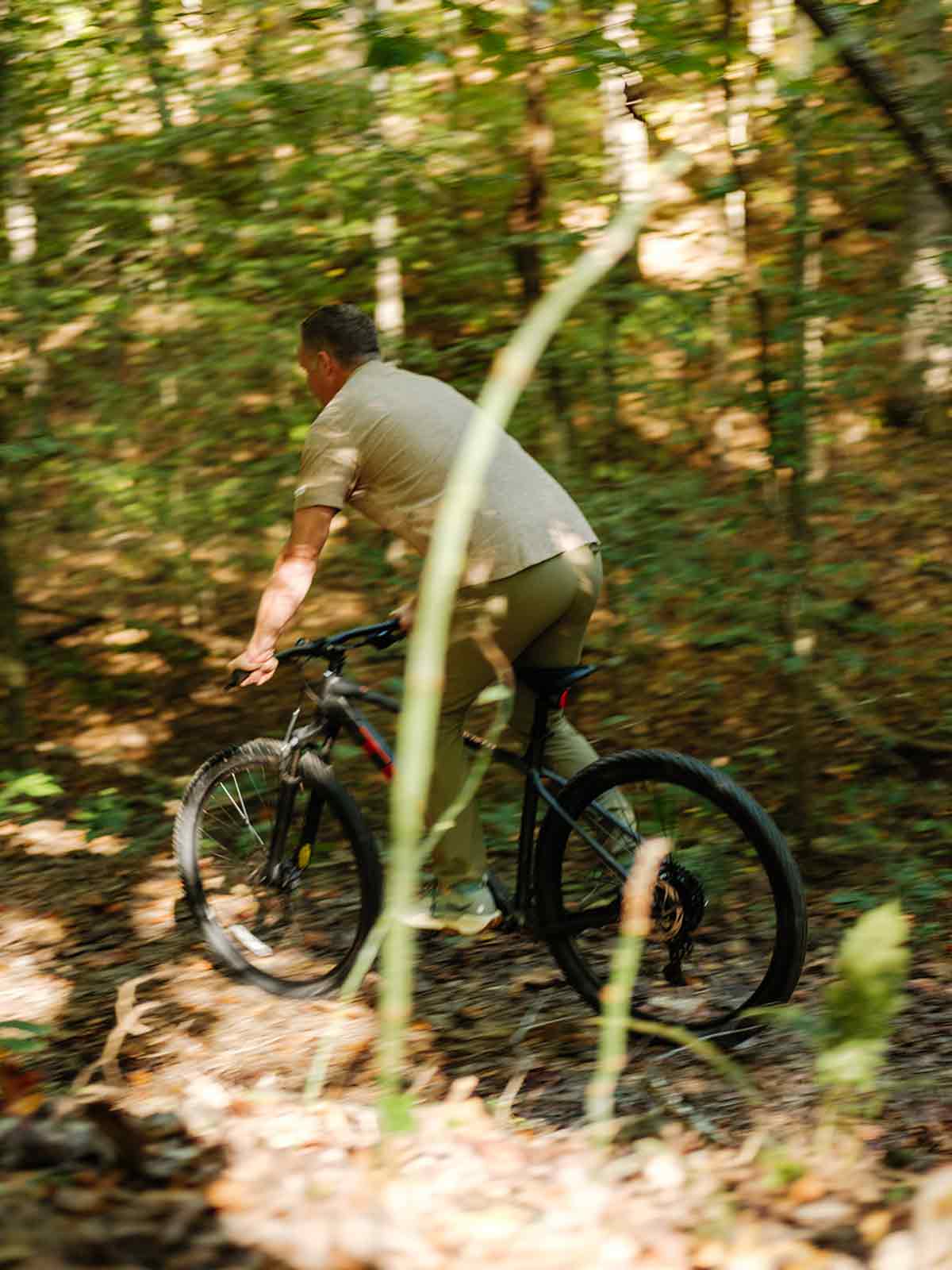Man riding a bike on a professionally designed trail in the forest of the private luxury community in Williamson County.