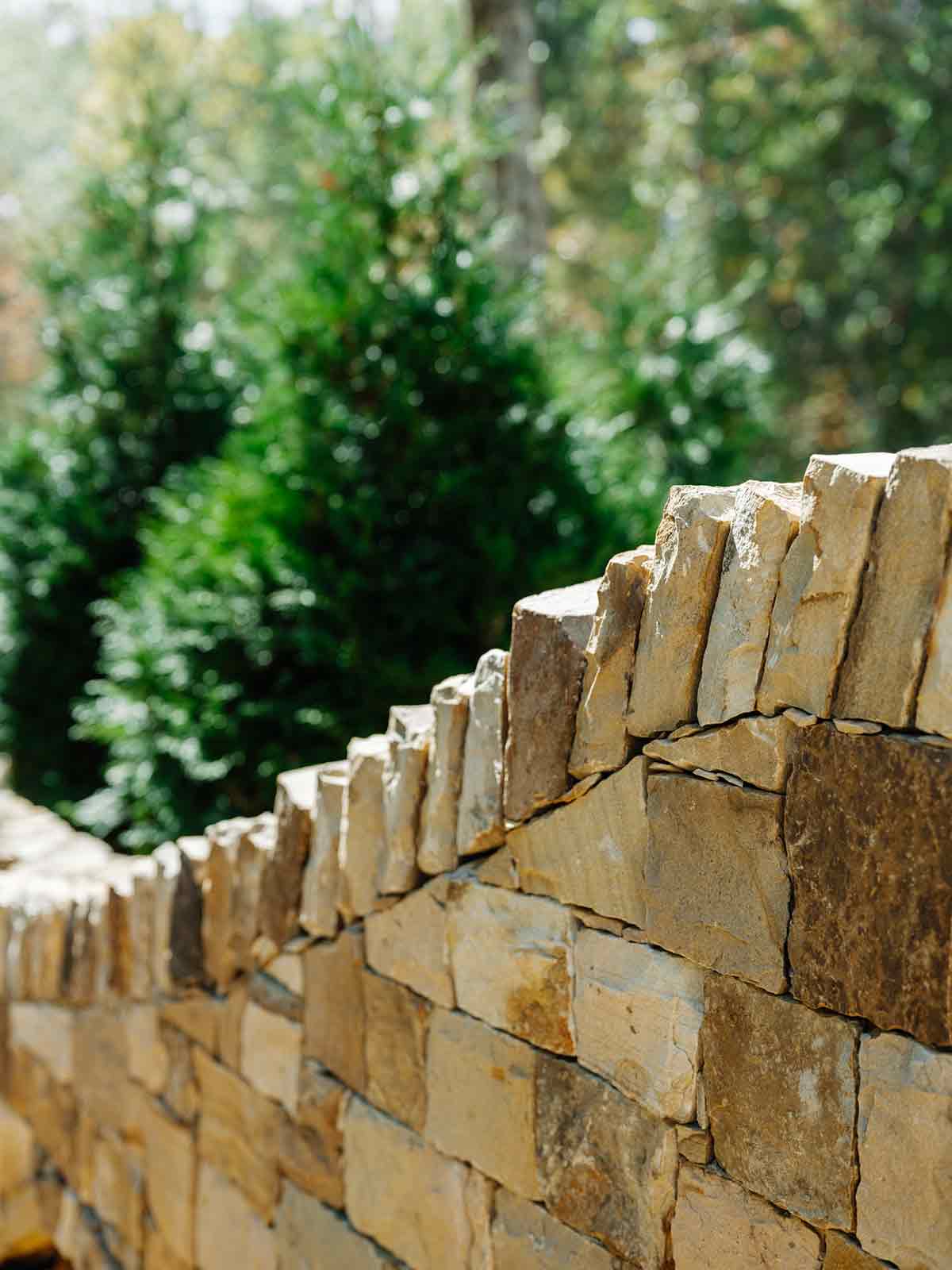 Beautifully crafted stacked stone fence, a feature of the refined luxury landscape at The Arbors development.